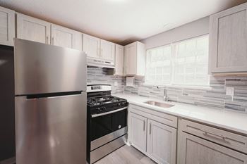 a kitchen with stainless steel appliances and white cabinets at BAY SHORE APARTMENTS, EAST HAVEN, CT, 06512
